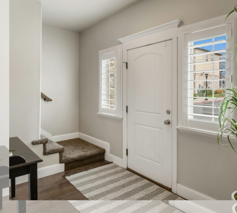 white open shutters on either side of front door